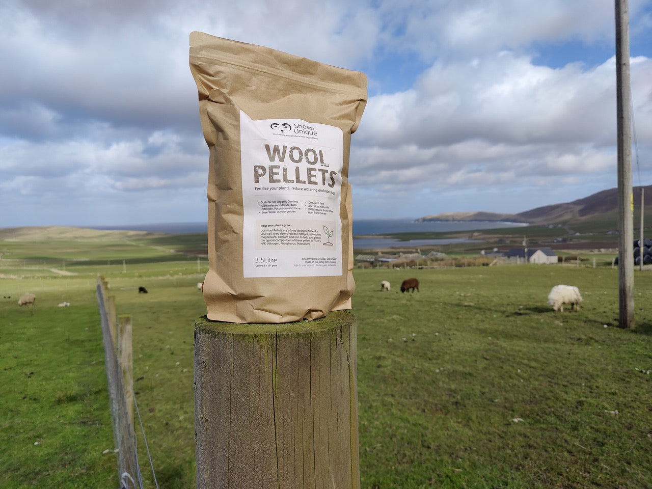 3.5 Litre bag of wool pellets on a fence post with island view and sheep behind