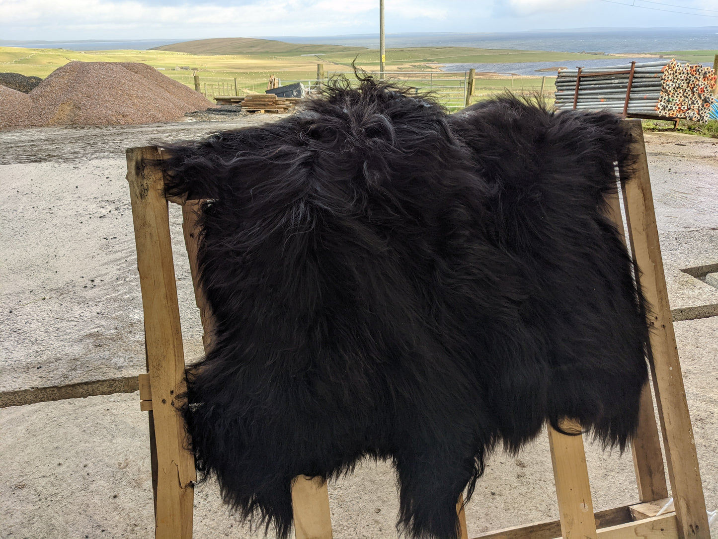 2 Black Sheepskin Rugs with our farm and the sea in the background, 